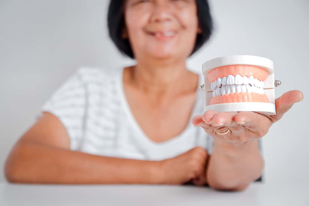 Woman Holding Dentures